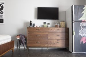 brown dresser with tv mounted above