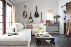 white sectional with guitars on wall