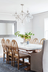 Rounded back wooden dining chairs around a white rectangular dining table