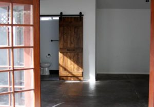 looking through front door to large open room with barndoor bathroom