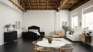 studio apartment room with black upholstered bed and white sofa on right