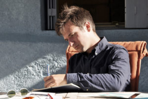 guy sitting in chair writing