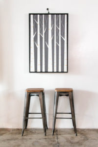 two stools under painting of trees