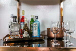 expensive liquor bottles with wine glasses on table