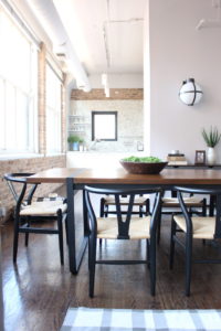 wood dining table with black chairs and rug