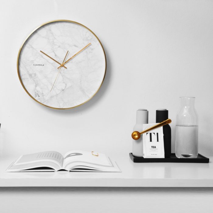 Round white marble face wall clock with gold hands and trim