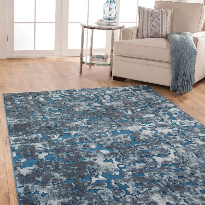 Blue area rug on a wood floor with a beige chair